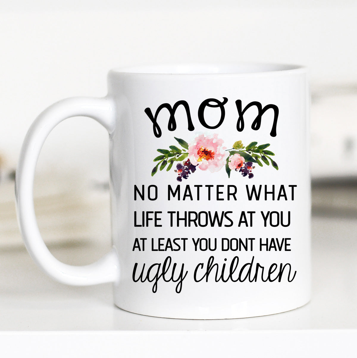 11 ounce white mug. Floral with print "mom no matter what life throws at you at least you don't have ugly children"