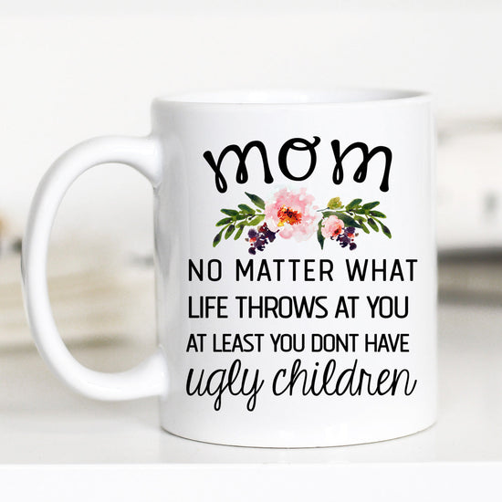 11 ounce white mug. Floral with print "mom no matter what life throws at you at least you don't have ugly children"