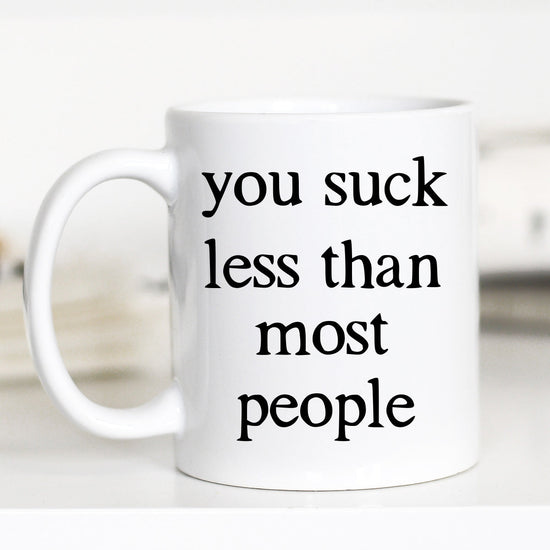 11 ounce white mug. "you suck less than most people"